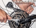 Stellen Sie noch einmal sicher, dass Achse und Bremsscheibe sauber und ohne zu verkanten im Hinterbau sitzen und die Nase der Drehmomentabstützung in die Öffnung der Ausfallenden greift. Drehen Sie dann beide Achsmuttern handfest zu. Ziehen Sie die Muttern abschließend mit zwei Schlüsseln gleichzeitig endgültig fest. 