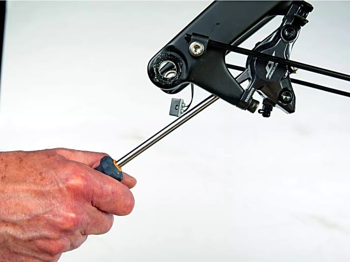 Das Auseinanderdrücken der Bremskolben funktioniert auch mit einem Schraubendreher. Wichtig: Immer die alten Beläge als Schutz zwischen Tool und Bremszange lassen!